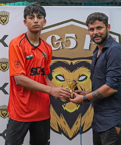 A player in his SGS kit proudly accepts his award, a testament to his skill and dedication during the match.