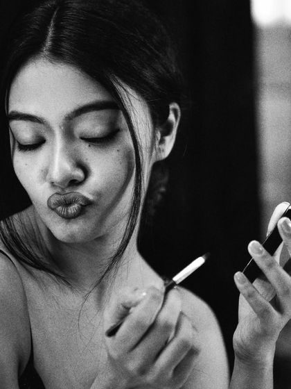 A playful, candid moment captured in beautiful black and white. This shot adds personality and warmth to the series, showing the model's character between the more serious, focused moments.