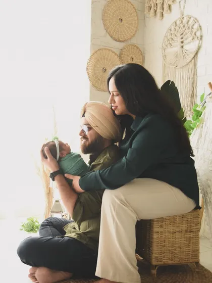 A warm, lifestyle family portrait with a newborn in our boho studio. The natural textures and earthy tones of the set create a cozy and inviting atmosphere for this family's first photoshoot.