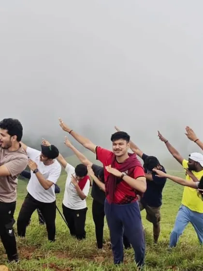 A fun, synchronized pose from one of our energetic groups on a grassy hilltop. It's all about creating happy memories.