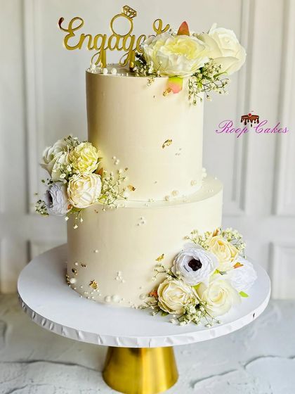 Love in every layer, simplicity in every design. This elegant two-tier engagement cake in a soft ivory is adorned with beautiful white flowers and delicate baby's breath.