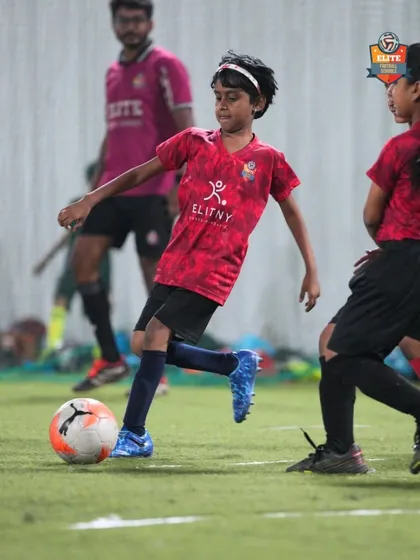 A young girl dribbles the ball with confidence, demonstrating the skills she has learned in our training sessions.