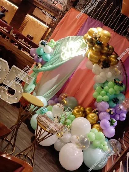 A vibrant and modern balloon ring decoration inside a restaurant for a 26th birthday party.