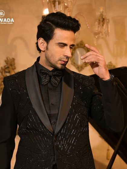 A contemplative pose in the black sequined tuxedo, highlighting its sharp tailoring and the way it catches the light.