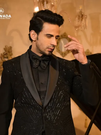 A contemplative pose in the black sequined tuxedo, highlighting its sharp tailoring and the way it catches the light.