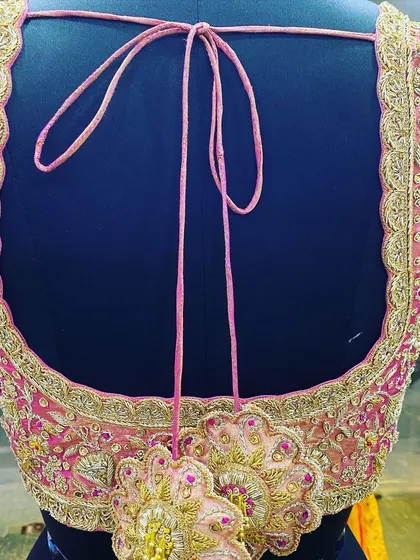 I make custom latkans (tassels) to match the blouse embroidery. This large, flower-shaped latkan is heavily embroidered and adds a unique touch to the deep U-shaped back design.