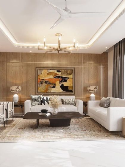 This living room is a haven of tranquil elegance, where a wood-paneled accent wall and a plush rug complement the clean lines of the sofas. Large windows bathe the room in natural light, highlighting the exquisite artwork.