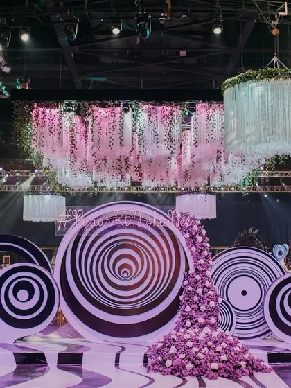 The entrance and photo-op area for the psychedelic Sangeet. Giant, hypnotic spiral discs and a cascade of purple flowers created a bold and immersive first impression for guests.