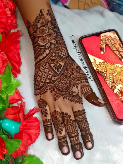 A beautiful party henna design with rose motifs and delicate net patterns on the fingers.