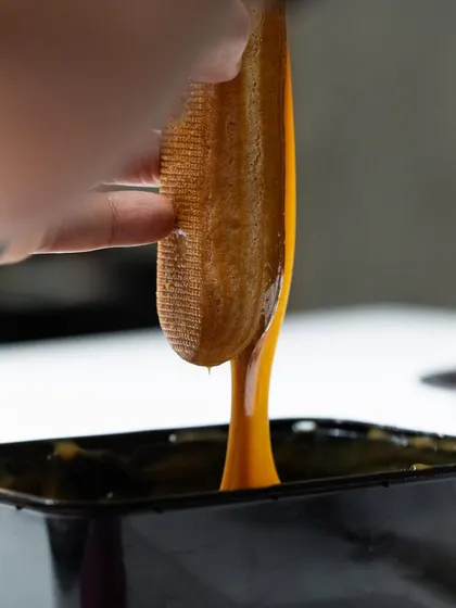 Testing the texture of a perfectly made caramel, demonstrating the importance of sensory evaluation in pastry.