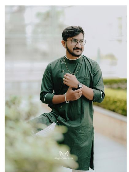 A handsome portrait of the groom in his green kurta, looking sharp and ready for the celebration.