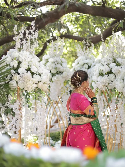 A shot from the back, capturing the bride amidst a beautiful garden setting.