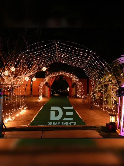 To welcome guests into this nighttime wedding event, I designed a magical entrance tunnel using arches wrapped in thousands of warm fairy lights. This created an immersive and enchanting pathway leading to the main celebration area.