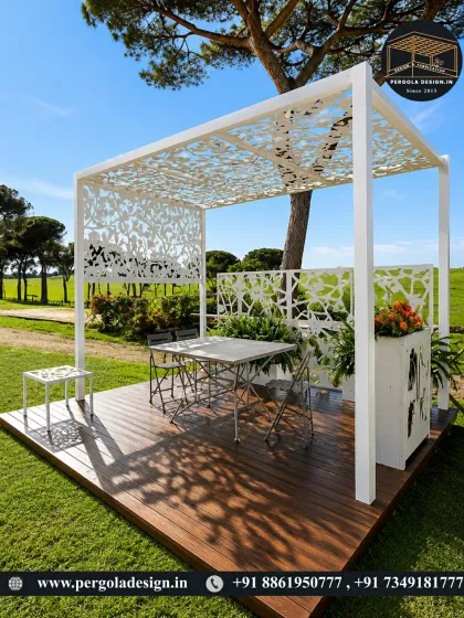 A beautiful example of a designer garden structure. This all-white pergola features intricate laser-cut panels for the roof and walls, casting artistic shadows on the wooden deck. It serves as a functional dining space and a stunning landscape sculpture.