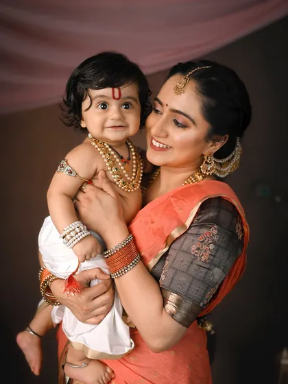 A tender moment between a mother and her little Kanha. For my cultural and festive photoshoots, I provide authentic traditional outfits and detailed backdrops to create timeless, artistic portraits like this one.