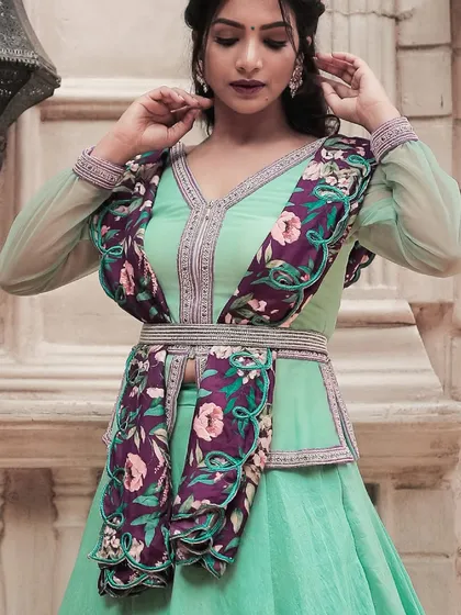The model showcasing the turquoise peplum blouse and printed dupatta, a chic and contemporary choice for pre-wedding festivities.