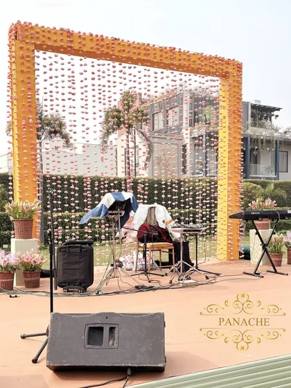 The stage for the live music, with a backdrop of hanging flower strings, perfectly integrated into the event's theme.