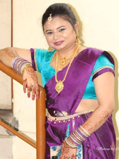 A relaxed portrait of a client ready for her engagement party. Her makeup is soft and pretty, complementing her purple and turquoise silk saree.