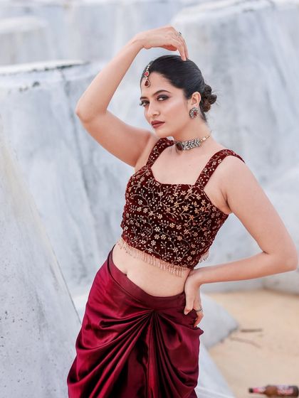 A beachside fashion shoot for a designer's modern-ethnic collection. The models are posed against the sea and coastal rocks to create a windswept, editorial feel that highlights the clothing.