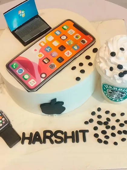The ultimate cake for a tech enthusiast. This design features edible replicas of an iPhone, Apple Watch, laptop, and a Starbucks coffee, representing all the modern-day essentials.