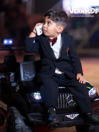 Making an entrance on his big day. We believe every milestone deserves an outfit that’s just as special, like this classic black tuxedo, tailored to perfection. It’s more than just a suit; it’s the start of a beautiful memory.