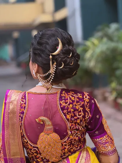 A close up shot that captures the texture of the Maharashtrian bun and the shine of the golden hair accessories. Every detail is placed to create a harmonious and beautiful bridal hairstyle.