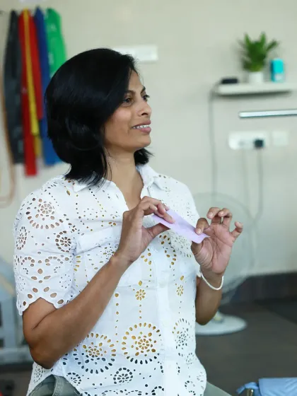 A woman in a lovely white top, engaged in the group activity.