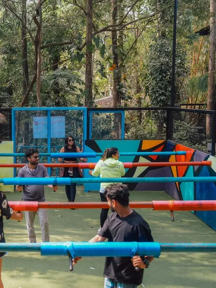 A game of Human Foosball in progress, with players holding onto the colorful poles and trying to score a goal.