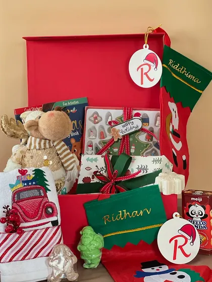 This Christmas hamper for kids is filled with holiday magic. It includes a plush reindeer, personalized stockings and ornaments, fun activity books, and of course, some sweet treats.