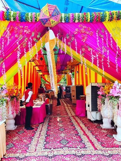 The grand entrance to the housewarming tent, adorned with flowers and colourful drapes, creating an impressive welcome.