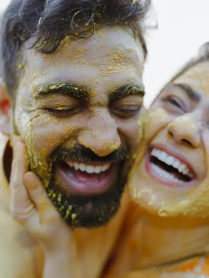 Pure, unadulterated joy. We believe the best moments are the unscripted ones, like this candid laugh during a Haldi ceremony, where love is smeared on with turmeric and happiness.