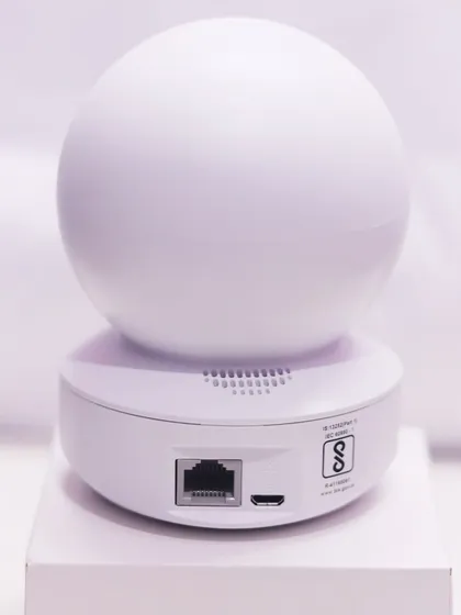 The back of this smart camera shows the ports for power and an ethernet cable, offering flexible connection options. It is also certified for quality and safety standards.