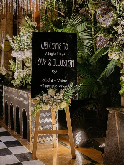"Welcome to a night full of Love & Illusion." The welcome sign for our monochrome Sangeet, complete with a lush floral arrangement, set the stage for the magic to come.