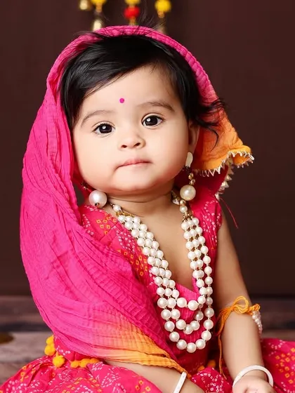 Dressed in a beautiful traditional pink and yellow bandhani outfit, this little girl looks absolutely radiant. This setup is perfect for celebrating cultural festivals or just creating timeless ethnic portraits.
