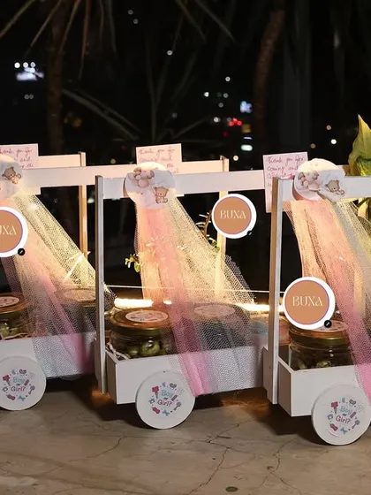 I had so much fun creating these luxury baby shower carts for a celebration in Gurgaon. Each custom white basket on wheels was filled with premium goodies like lemon masala makhanas, Theobroma cookies, and a ceramic bonsai planter to delight every guest.