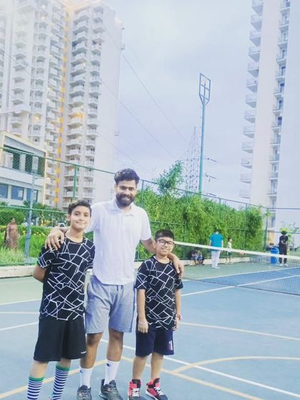 More teammates and friends, posing for a photo on the court against the Gurugram skyline.