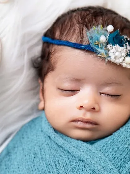 A close-up of the baby's face from our ocean theme, highlighting the delicate seashell and feather headband. We use high-quality, baby-safe props and accessories.