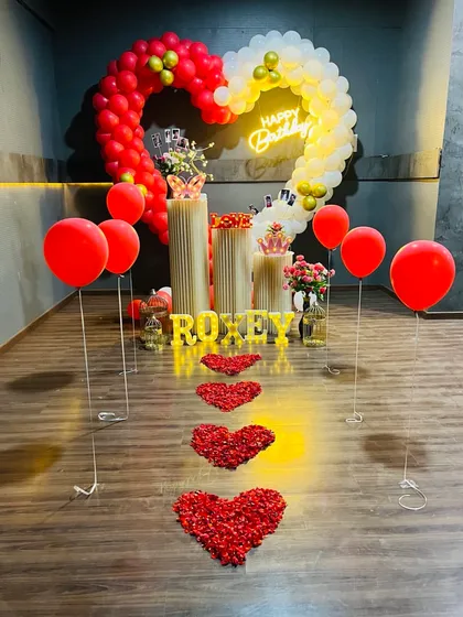 Another take on a romantic birthday surprise. This design features a heart-shaped balloon arch, a pathway of rose petal hearts, and a personalized light-up name sign for a truly memorable celebration.