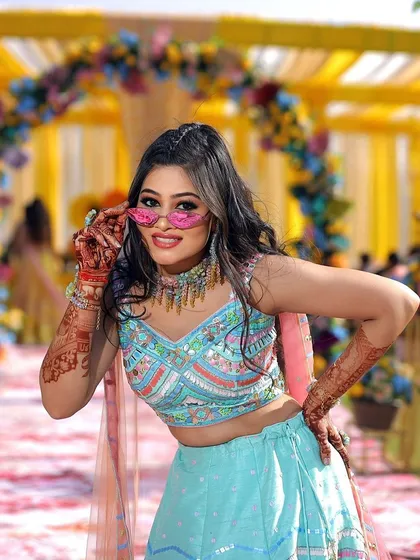 Fun and fashion at a Haldi event. Our client pairs her custom colorful jewelry set with playful pink sunglasses, showing how accessories can express your personality.