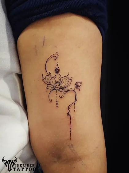 This fine-line piece shows a figure meditating within a lotus flower, symbolizing purity and rebirth. The delicate dot work adds a touch of elegance to this spiritual design.