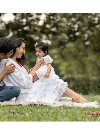 A serene outdoor portrait of a family enjoying a quiet moment together on the grass.