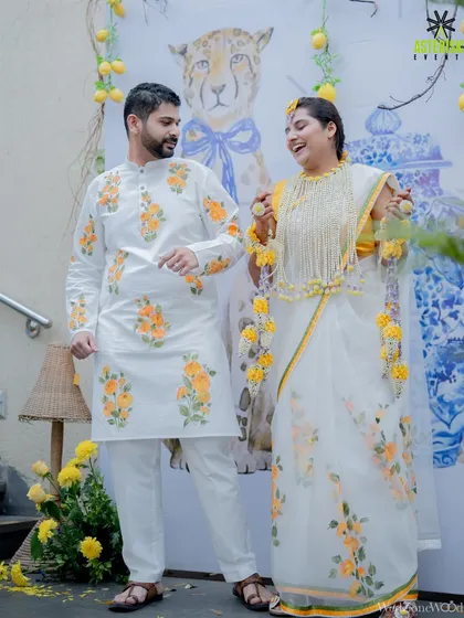 The couple shares a playful moment during their Haldi, dressed in matching hand-painted outfits.
