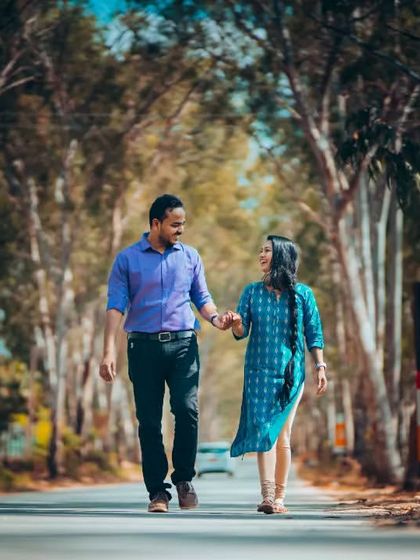 A couple enjoys a walk down a beautiful tree-lined road, hand in hand. We find picturesque locations that serve as the perfect backdrop for your love story.