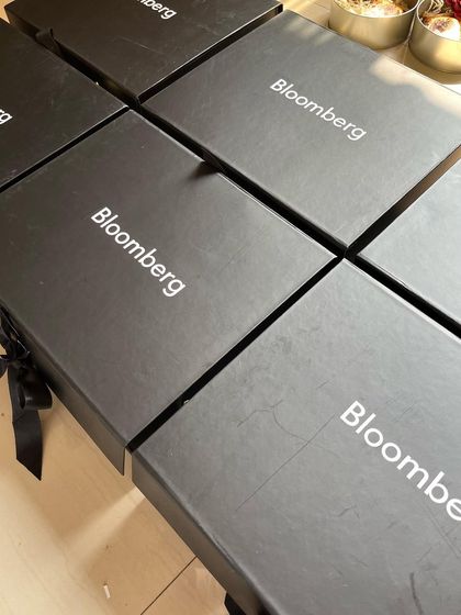 A stack of the sleek, custom-branded "Bloomberg" boxes, showcasing the professional and high-quality packaging we provide for our corporate clients.
