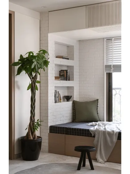 This versatile guest room features a daybed with built-in book niches and black plaid upholstery. The cozy reading nook is illuminated by a swinging wall light, making it a perfect spot for relaxation.