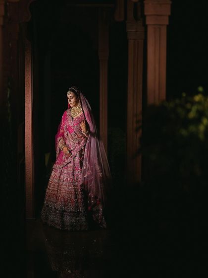 An artistic, wide-angle shot of the bride, showcasing her magnificent lehenga and the elegance of her complete look.