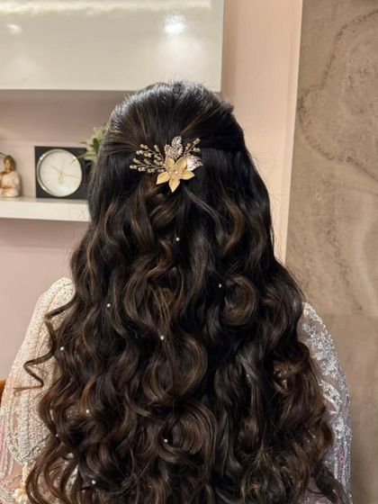A detailed look at the elegant half-up hairstyle, adorned with a beautiful hair accessory. This style is perfect for keeping hair off the face while dancing.