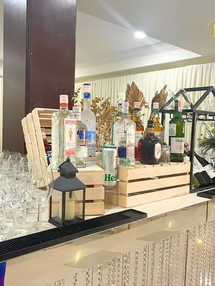 A beautiful, rustic-chic bar setup featuring a crystal-draped front and wooden crate displays. This look combines glamour with a relaxed, natural feel.