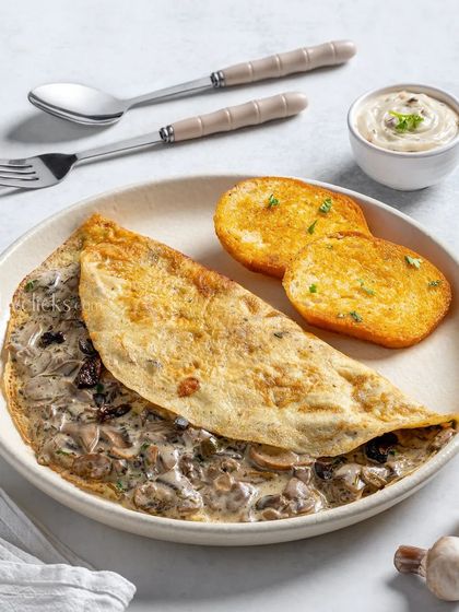 A creamy mushroom omelette served with toasted bread, a classic and elegant breakfast dish.