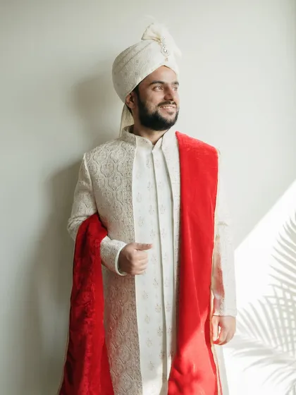 The groom's story is just as important. This portrait captures the groom in a moment of quiet confidence and anticipation, highlighted by artistic shadows and light, showcasing his elegance on the wedding day.